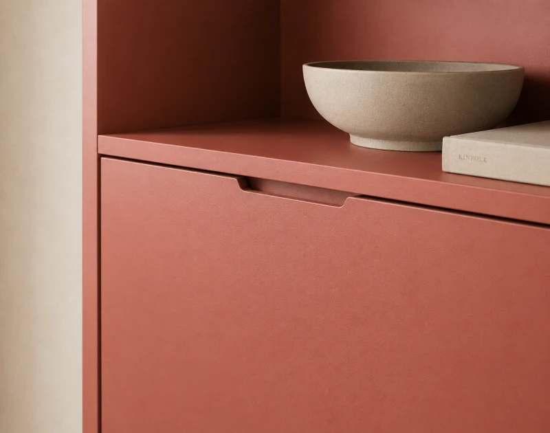 Close-up of a terracotta-colored cabinet with a bowl in a minimalist interior